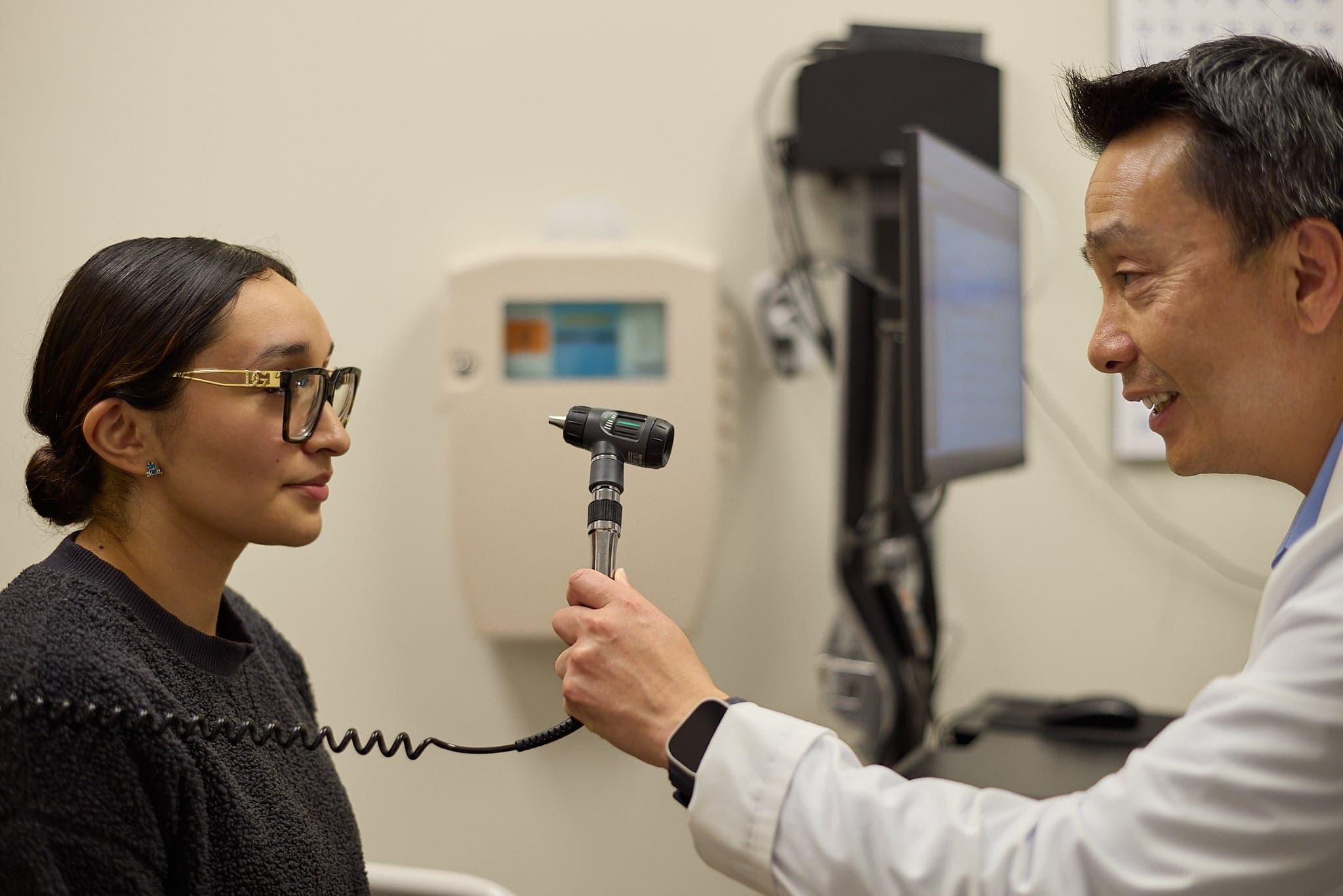 A doctor holds an instrument up to a patient's forehead