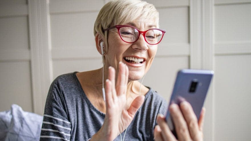 Older woman having a face-time video call with a friend.