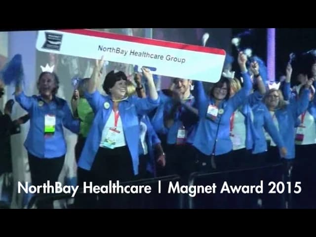 NorthBay Healthcare Group team members in blue jackets celebrating with raised arms at Magnet Award 2015 ceremony