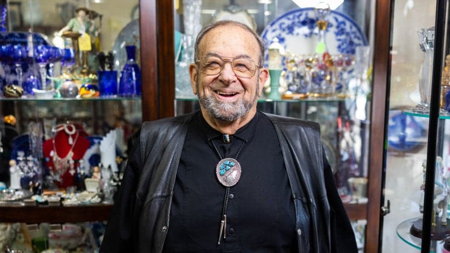 Ted Neima, Vacaville resident, smiling at the camera in front of a display cabinet in his store Clipper Cargo.