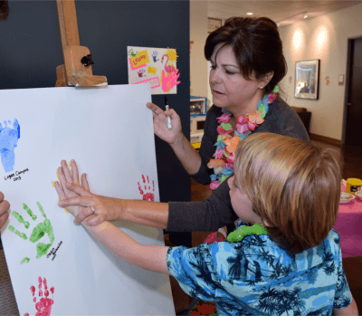 NICU nurse Jana Parkinson helps Andrew Ross of Benicia place his handpprint in yellow on a piece of canvas that will be displayed at NorthBay Medical Center.