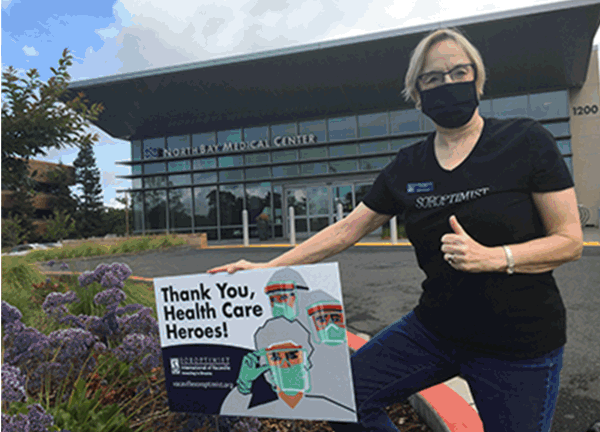 Mary Dieckey, RN, poses with a sign created through Soroptimist International. The signs have been purchased and placed at each Northbay campus.