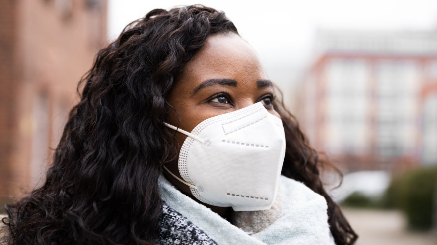 A woman wearing a N95 mask to keep herself safe as she goes about her day.