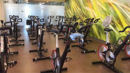 Multiple rows of exercise bikes inside the cycling room at the fitness center.