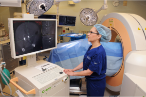 Dr. Edie Zusman is able to use the O-arm/Interoperative CT and Stealth Image Guidance system (the pale orange and white piece of equipment behind her) to perform complex spinal surgeries.