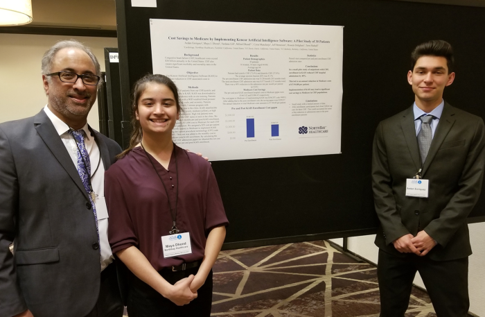 Milind Dhond, M.D., (left) with daughter, Maya Dhond, and U.C. Berkeley freshman Aedan Enriquez, pose for a photo with a display of their research.