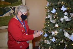Volunteer Gloria Queen writes names of lost loved ones on seed paper cut into the shape of butterflies and placed on the Tree of Memories.