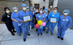 Members of the Central Sterile team surround manager Darlene Capenhurst (center, with balloons) and Katie Lydon, senior director for Perioperative Services (at left) after receiving a Secret Ray of  Sunshine on a sunny afternoon.