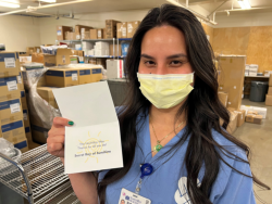 Natalie Ison, a Supply Chain technician, shows the card she received from the Secret Ray of Sunshine saluting her efforts and those of her team throughout the pandemic.