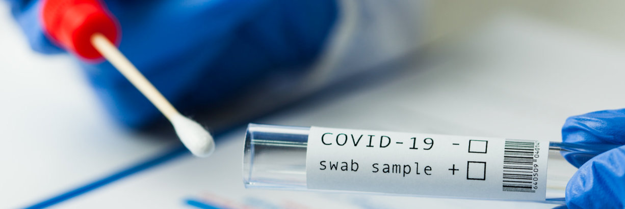 Close-up of a lab technician handling a Covid-19 test.